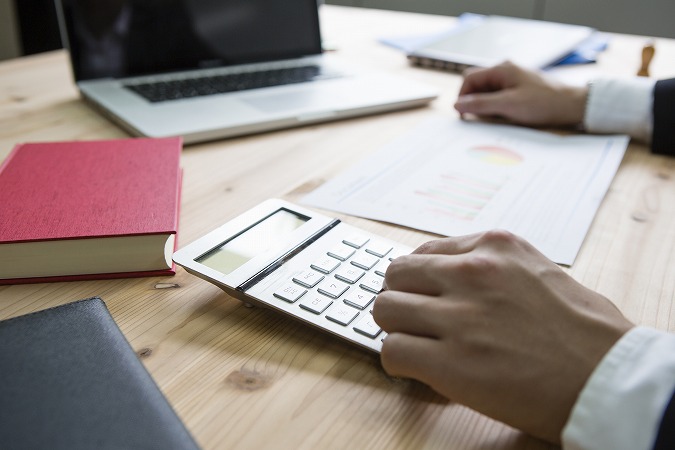 電卓を打つ男性